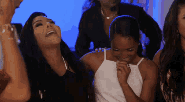 a group of women are laughing and having fun at a party