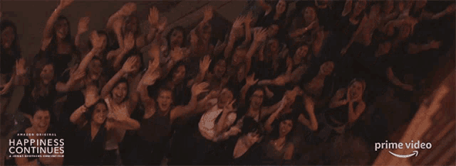 a poster for the happiness continues shows a crowd of people with their arms in the air