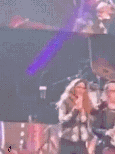 a man and a woman are dancing on a stage with a yellow l on the bottom right