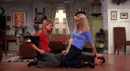 a man is laying on the floor while two women kneel around him