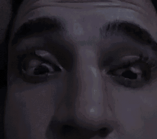 a close up of a man 's face with his eyes closed and his mouth open .