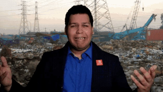 a man wearing a blue shirt and a black jacket with an nintendo switch logo on his jacket