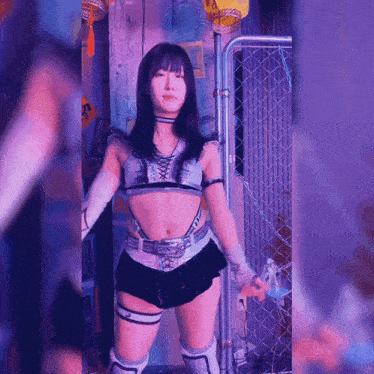 a woman is standing in front of a chain link fence with a sign that says ' n. ' on it