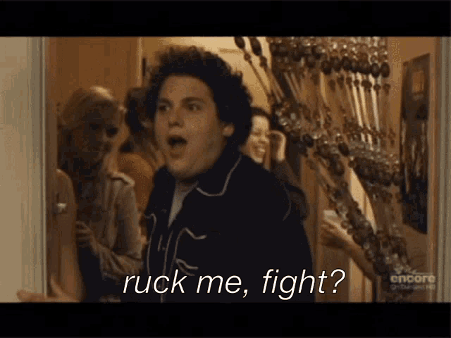 a man says " ruck me fight " while standing in front of a group of people