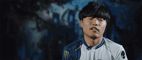 a man wearing a monster energy shirt is making a face .