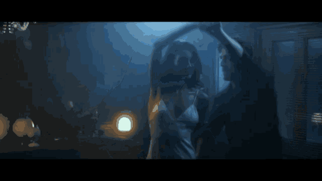 a man and woman are dancing together in a dark room