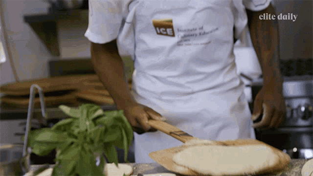 a man wearing a white apron that says ice is cooking in a kitchen