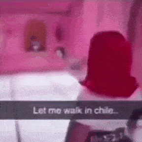 a woman with red hair is standing in a pink room and talking to someone .
