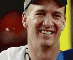 a man wearing a hat and a towel smiles