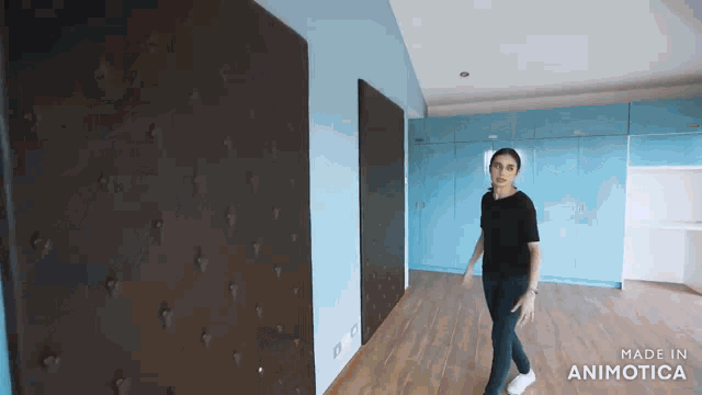 a woman in a black shirt is walking down a hallway with the words made in animotica on the bottom