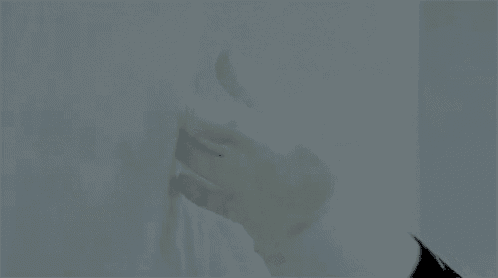 a close up of a person 's hand in a white glove touching a white wall .