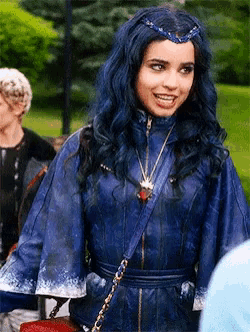 a woman with blue hair and a crown on her head is wearing a blue leather jacket .