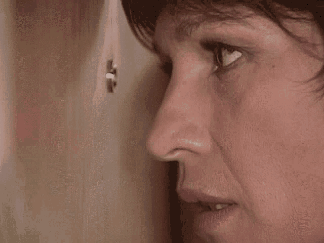a close up of a woman 's face looking through a peephole .