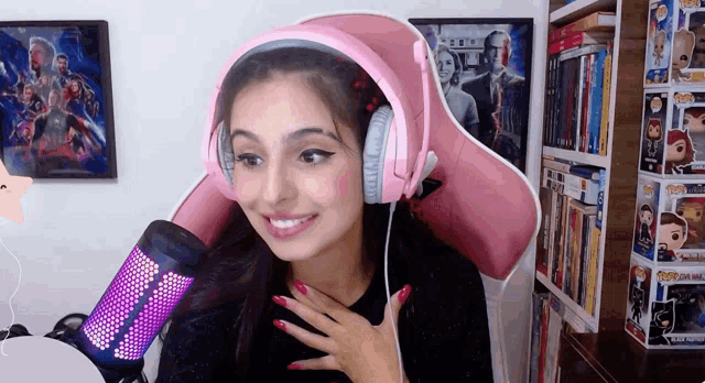 a woman wearing pink headphones and a pink chair is smiling