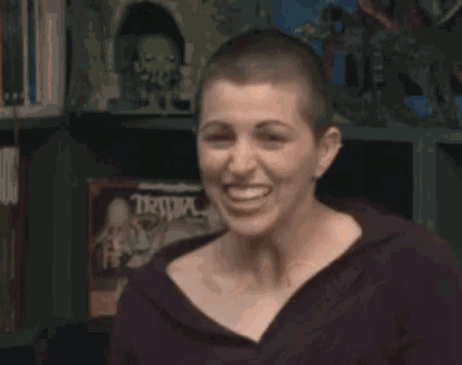 a woman with a shaved head is smiling with the words are you not behind her