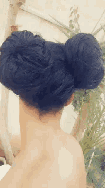 the back of a woman 's head with a bun