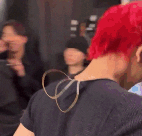 a man with red hair is wearing a black shirt and headphones .