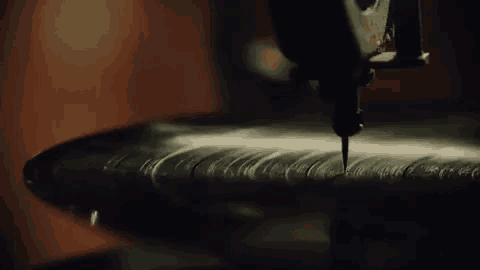 a machine is cutting a record on a record player .