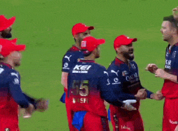 a group of cricket players are standing next to each other on the field .