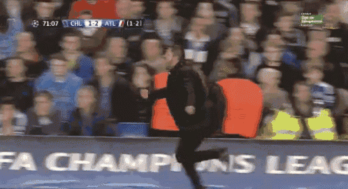 a man in an orange vest is running in front of a sign that says fa champions league
