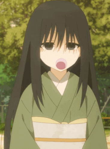 a girl with long black hair is wearing a green kimono and making a funny face