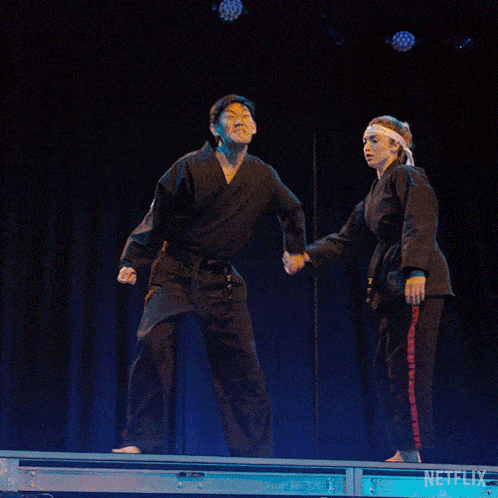 a man and a woman in karate uniforms on a stage with a netflix logo in the corner