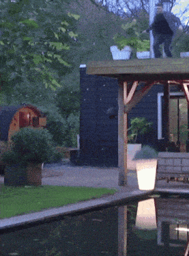 a man stands on a wooden deck overlooking a pool