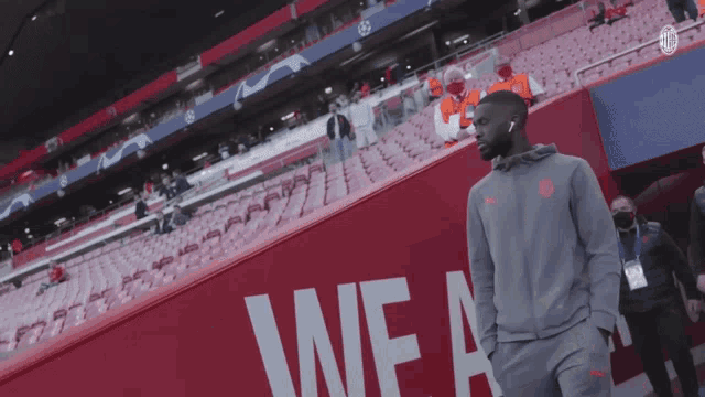 a man stands in front of a wall that says we a on it