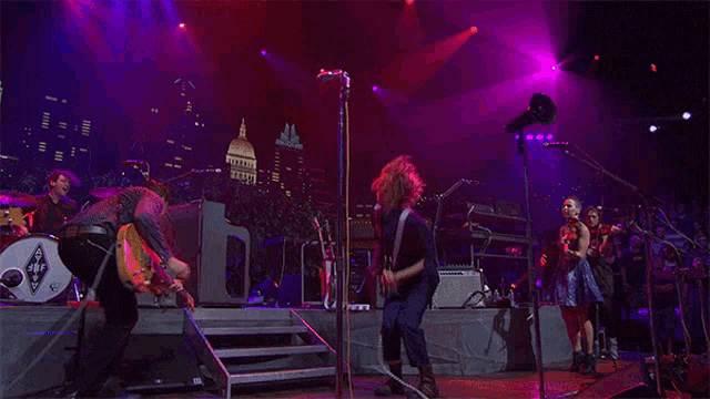 a group of people playing instruments on a stage with a drum that has the letter s on it
