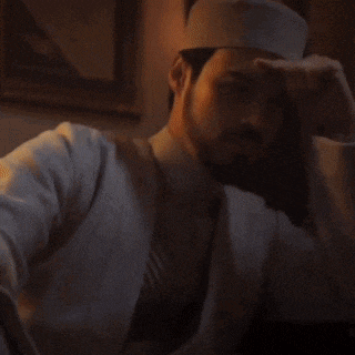 a man with a beard wearing a white hat and a white jacket