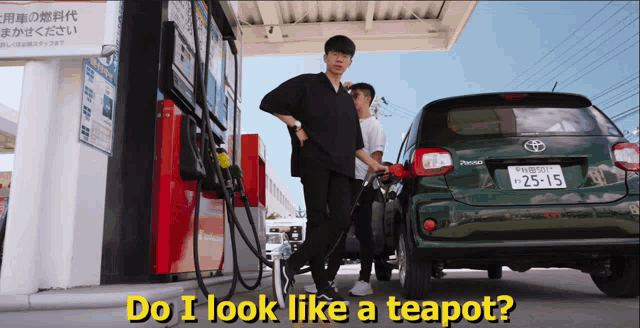 a man is pumping gas into a green toyota car