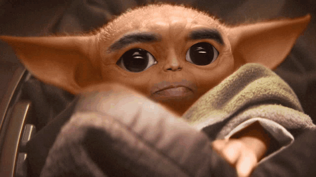 a close up of a baby alien with big eyes and a beard
