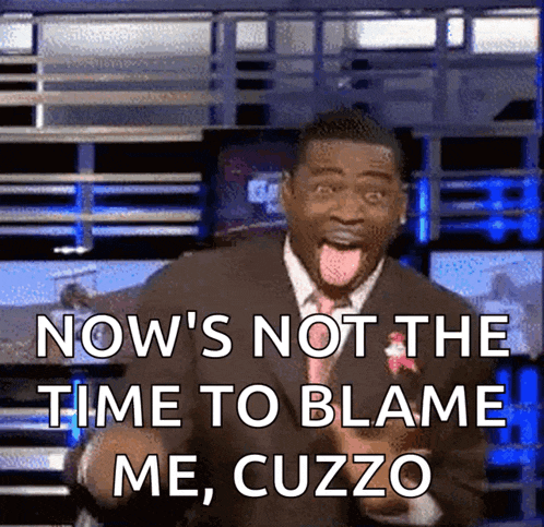a man in a suit and tie is sticking his tongue out and says now 's not the time to blame me cuzzo