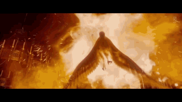 a silhouette of a person flying through a fire filled sky