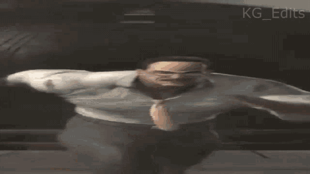 a man with glasses and a tie is running in a dark room with the words kg edits visible in the corner