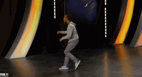 a man is dancing on a stage with the fox 11 logo in the corner