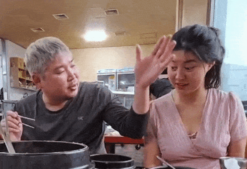 a man and a woman are sitting next to each other in a restaurant .