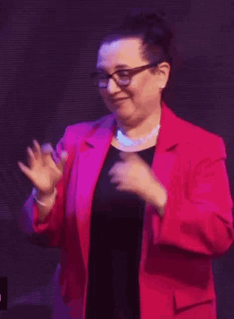 the woman is wearing glasses and a pink jacket