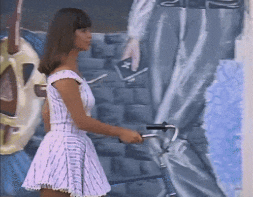 a woman in a white dress is holding a bicycle in front of a mural