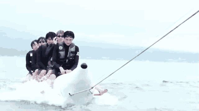 a group of people are riding on a banana boat in the water .