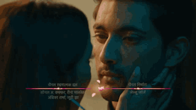 a woman touching a man 's face with a purple line that says ' a ' on it