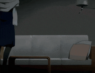 a woman in a blue dress is standing next to a couch