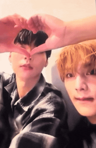 two young men make a heart with their hands