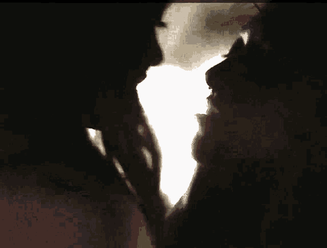 a close up of two people 's faces in a dark room