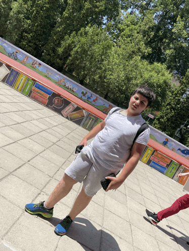 a boy standing in front of a mural that says " a "