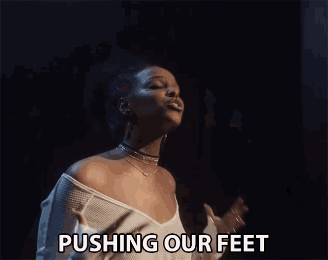a woman singing a song with the words pushing our feet