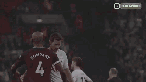 a soccer player with the number 4 on his jersey talks to another player