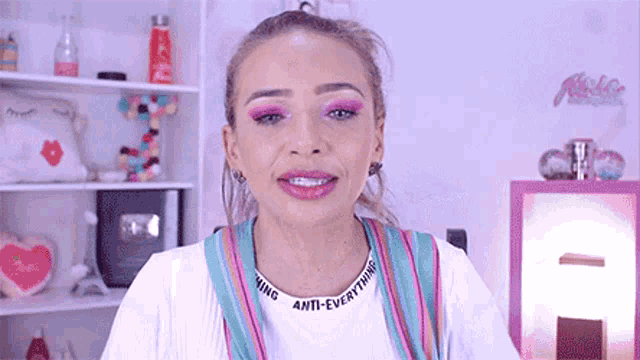 a woman wearing a white shirt with the word anti-everything on it
