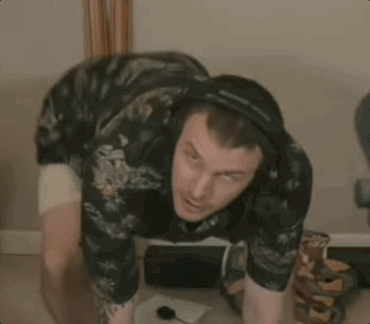 a man wearing headphones is squatting on the floor .