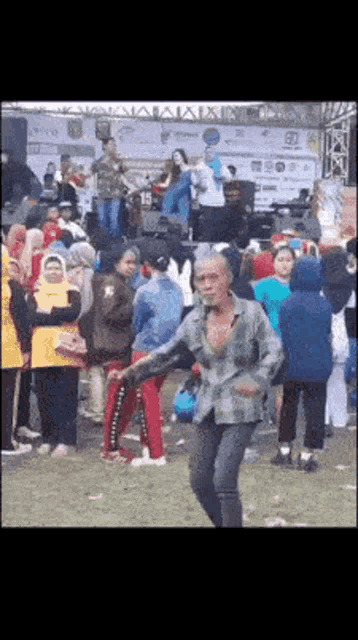 a man is dancing in front of a crowd at a festival